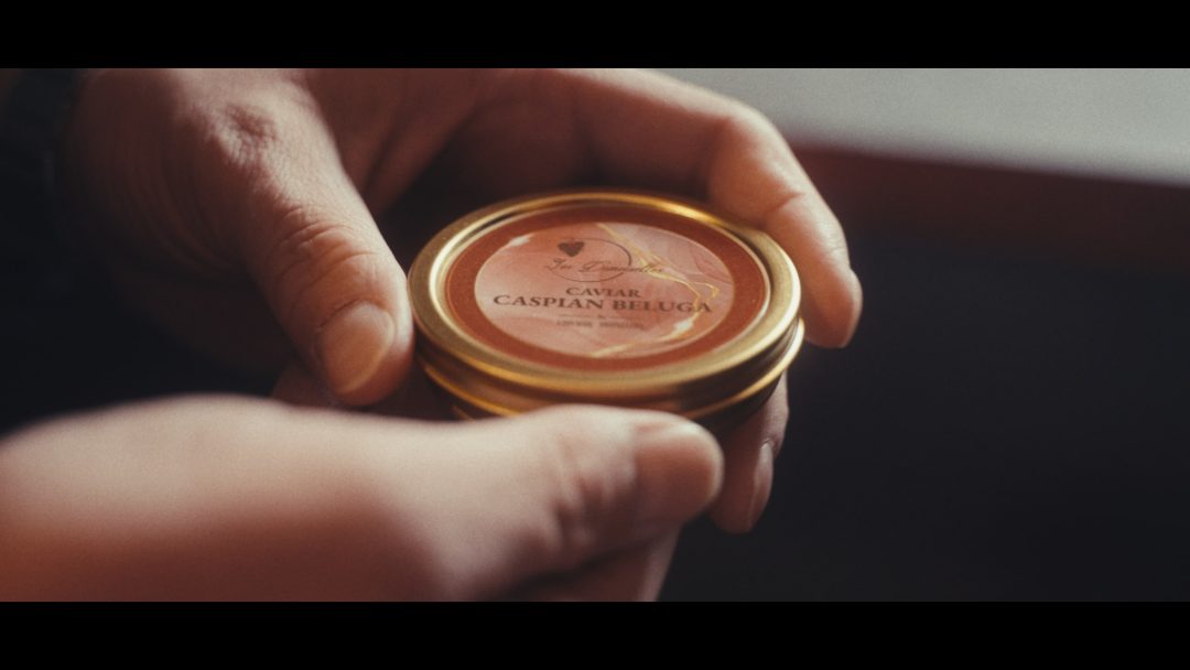 Close-up of hands holding a tin of caviar.
