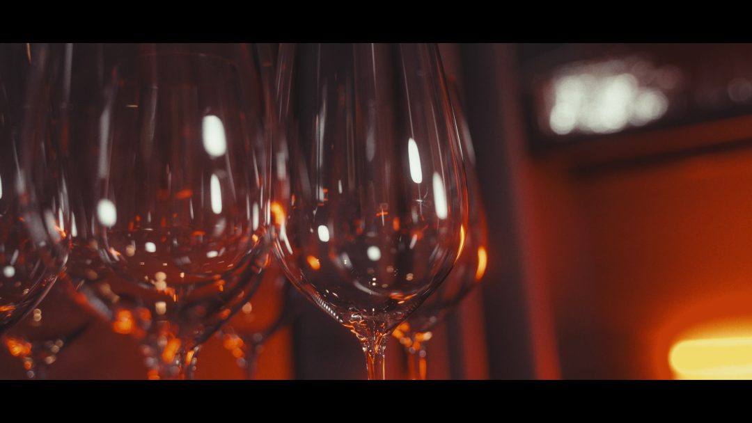 Close-up of empty wine glasses with warm orange lighting.