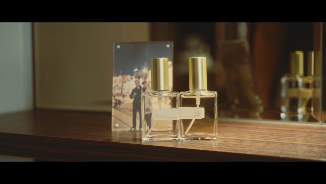 Perfume bottles on table with photo reflection in background.