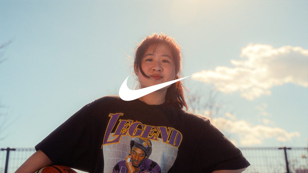 Girl in Kobe Bryant Legend shirt holding basketball with Nike logo visible.