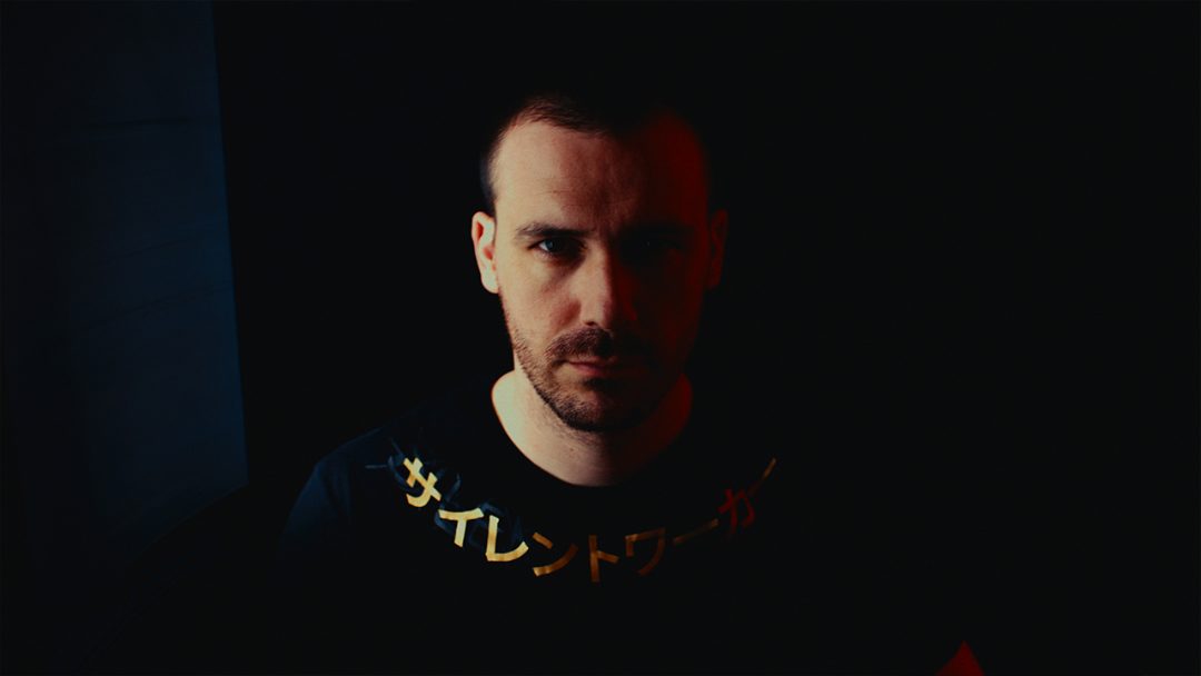 Man in black Silent Worker shirt under cinematic lighting.