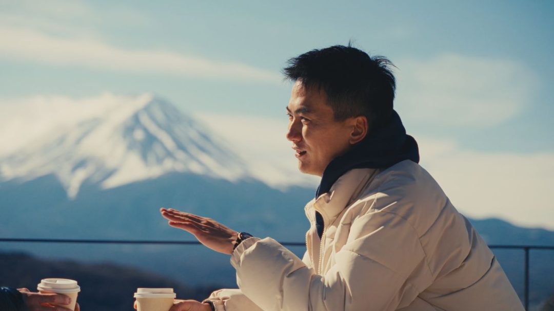 Japanese Male drinking coffee and talking with mt fuji on the background